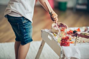 Cut girl painting in at her home.